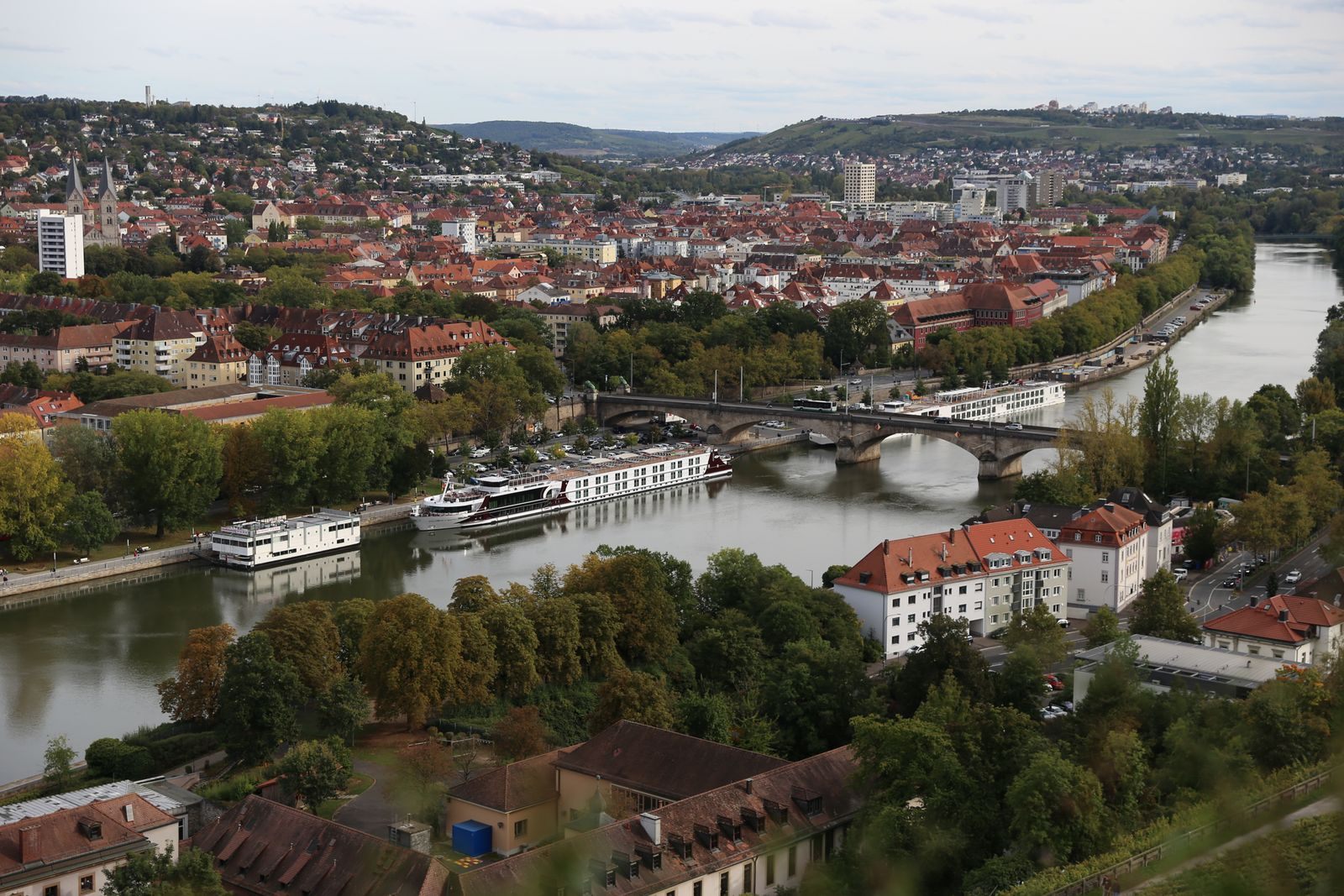 River ships moored on the Main below Würzburg&rsquo;s churches and Old Main Bridge
